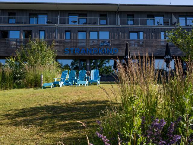 Außenansicht des Hotels Strandkind im Sommer mit Liegen